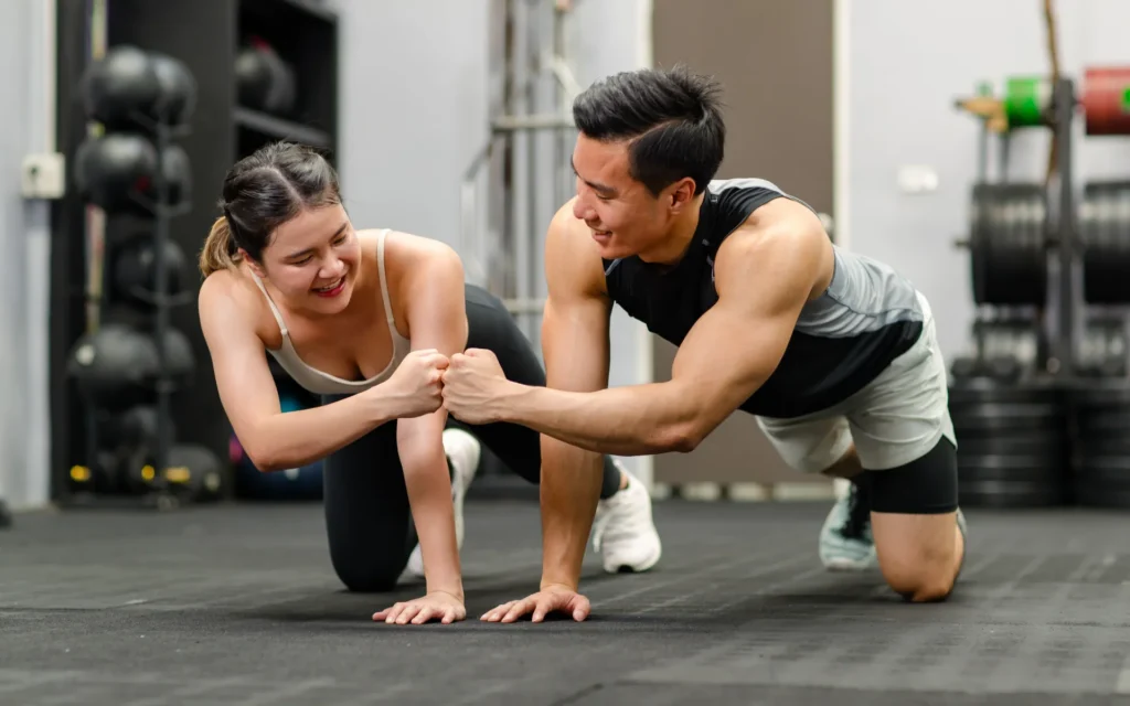 ติดตามผลการฝึกบอดี้เวท คู่ฝึกเล่นท่า Plank ในฟิตเนสพร้อมจับเวลาและบันทึกจำนวนเซต
