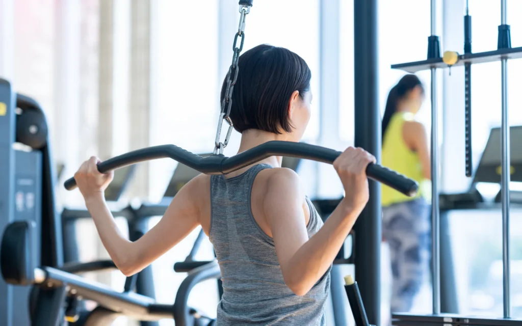 เวทเทรนนิ่ง (Weight Training) คือการฝึกด้วยแรงต้านจากอุปกรณ์ ผู้หญิงกำลังเล่นเครื่อง Lat Pulldown ในฟิตเนส